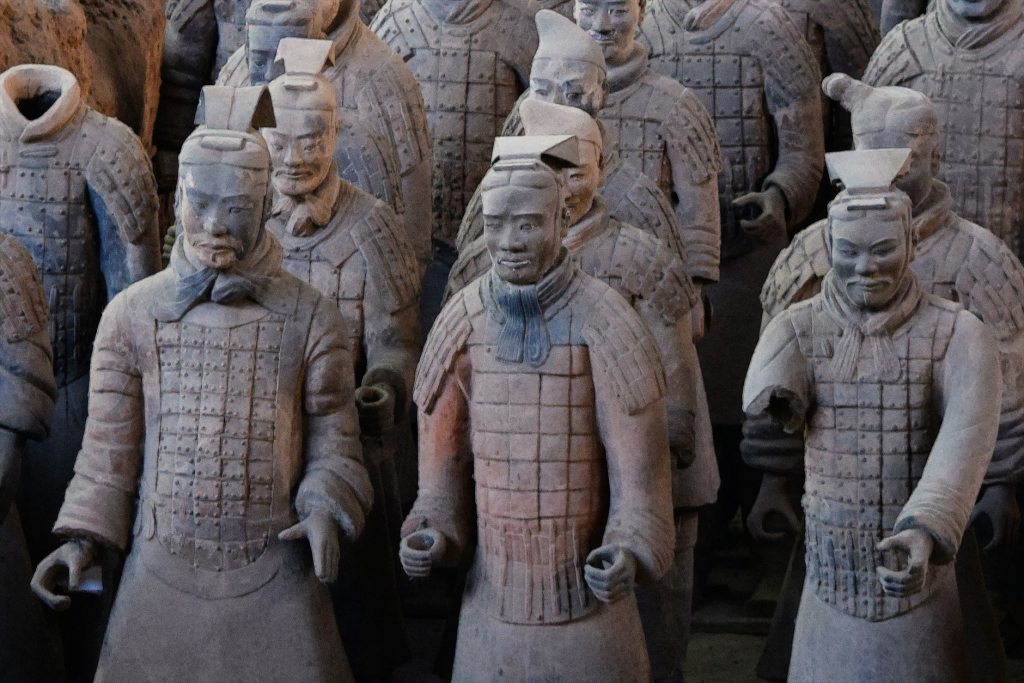 Mehrere Steinstatuen, die in einer Reihe stehen.